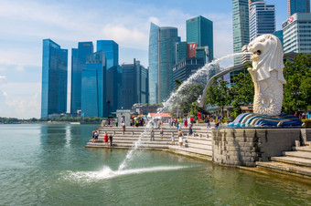 阳光明媚的一天的鱼尾狮喷泉的背景摩天大楼和游客编辑使用只有象征<strong>新加坡</strong>鱼尾狮