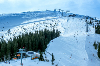 滑雪者的滑<strong>雪坡</strong>两个行滑雪电梯的太阳几乎没有休息时间通过的云多云的滑<strong>雪坡</strong>和滑雪电梯