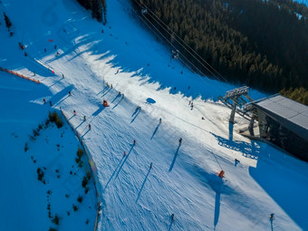 滑雪山坡上的树木繁茂的山滑雪电梯站阳光明媚的天气空中视图滑雪山坡上的树木繁茂的山空中视图