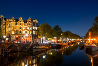 荷兰平静的晚上运河阿姆斯特丹住宅驳船和船是停泊反射的水<strong>传统</strong>的房子和桥阿姆斯特丹运河与船和<strong>传统</strong>的房子晚上