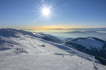 斯洛伐克冬天滑雪度假胜地明亮明亮的太阳的蓝色的天空在的滑<strong>雪坡</strong>山山峰和雾的地平线明亮的太阳在的滑<strong>雪坡</strong>和雾在的山山峰的地平线