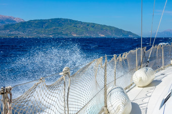 希腊阳光明媚的和多风的一天的海湾哥林多左一边白色航行游艇和水喷雾一边白色游艇和水喷雾