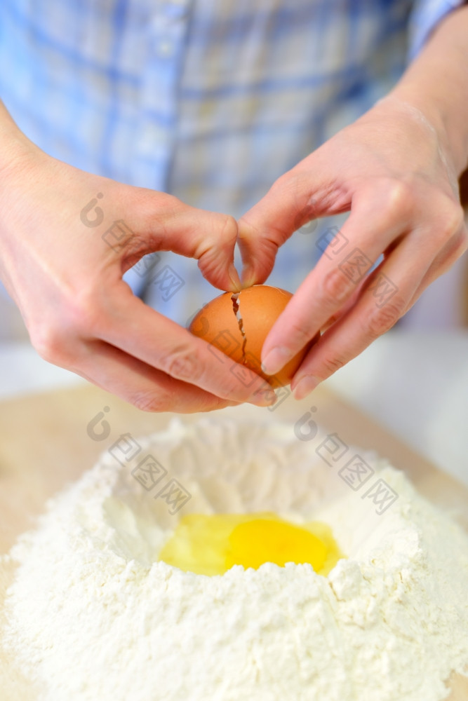 烹饪女人使面团添加鸡蛋面粉