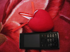 红色的心与红色的而且白色条纹而且移动电话