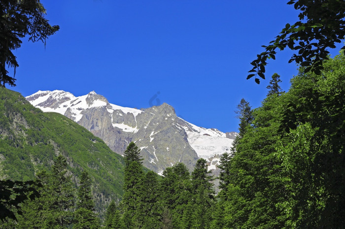的高加索地区山山峰下雪和清晰的蓝色的天空