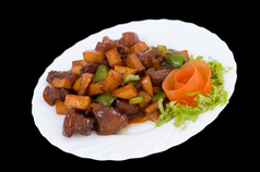 中国人食物炸猪肉与土豆而且红辣椒下酸甜蜜的酱汁装饰与番茄花