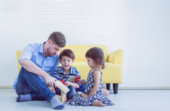 <strong>高加索</strong>人爸爸和小孩子们玩玩具在一起的地板上首页