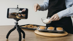 女食物博主流媒体首页与智能手机而烹饪