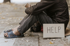 一边视图无家可归的人男人。街与杯帮助标志