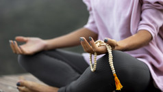 女人做瑜伽在户外持有念珠
