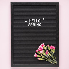 你好春天登记与粉红色的花黑色的董事会