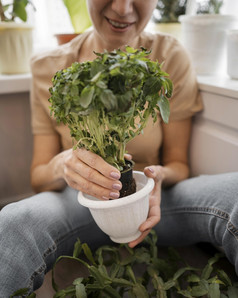 前面视图笑脸女人持有能植物