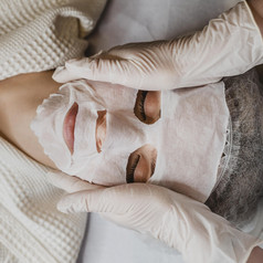 剥躺年轻的女人得到皮肤面具治疗