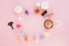 化妆品海绵不同的颜色与使产品粉红色的背景
