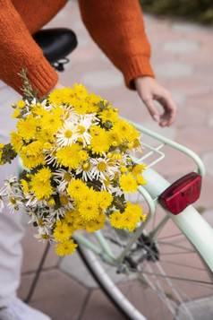 女人抓住自行车与花束花在户外