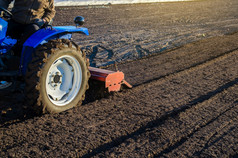 农民拖拉机培养农场场软化的土壤和准备为切割行为的下一个播种季节的春天土地培养小农场工作农业行业