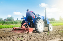 农民拖拉机与铣机流程放松土壤的农场场准备为新作物种植放松表面培养的土地磨和混合土壤种植园