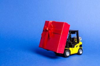 黄色的叉车卡车携带红色的礼物盒子与弓购买和交付现在零售折扣和竞赛比赛促销活动增加销售和吸引新客户