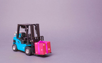 蓝色的叉车卡车携带粉红色的礼物盒子与弓购买和交付现在零售折扣和竞赛比赛促销活动增加销售和吸引新客户