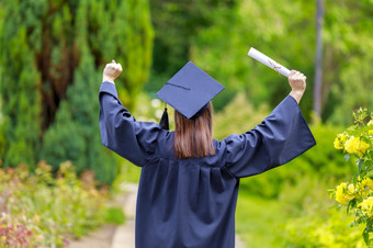 年轻的女人研究生把她的手和庆祝与证书她的手和感觉幸福年轻的女人毕业一天图片<strong>毕业生</strong>是庆祝
