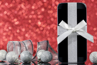<strong>智能</strong>手机和装饰为圣诞节树黑色的玻璃表格在红色的背景焦点<strong>智能</strong>手机