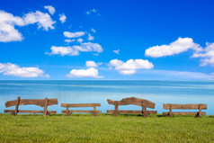 四个木长椅前面的海与蓝色的天空