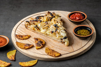 阿根廷<strong>披萨</strong>与洋葱切割董事会与各种各样的配料和烤箱炸土豆