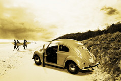古董冲浪场景与四个冲浪登机伴侣走从他们的六十年代海滩车的海洋海岸线