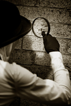 复古的私人眼睛侦探搜索为线索调查怀疑犯罪场景墙与放大看玻璃