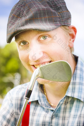爱好高尔夫球手男人。微笑后面他的高尔夫球俱乐部在周末洞轮当地的高尔夫球课程