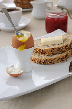 半熟的蛋与片燕麦片面包与黄油为早餐