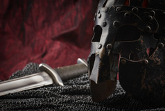 中世纪的甲头盔而且剑红色的帆布背景