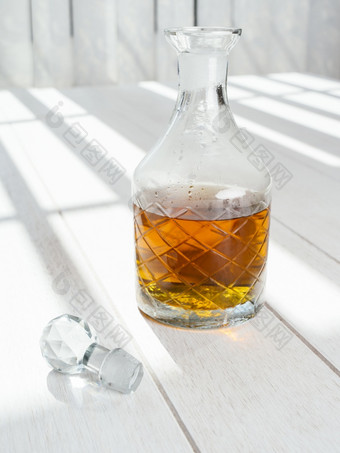 老<strong>威士忌</strong>玻璃水瓶站白色木表格