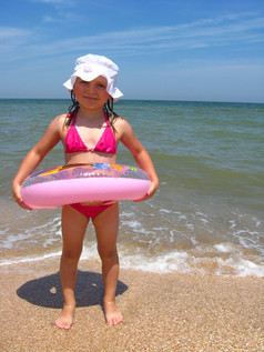 的小女孩与充气圆的沙子的海小女孩与充气圆的海