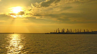 全景晚上海与码头和起重起重机晚上海洋景观日落以上海晚上海与起重起重机海港