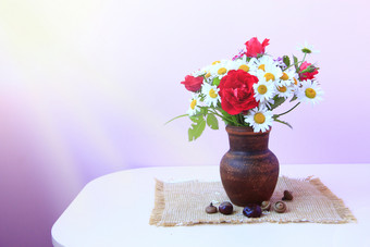 花束白色雏菊和红色的玫瑰粘土能解雇花能淡紫色背景Chamomiles和红色的玫瑰花瓶表格花能淡紫色背景Chamomiles和红色的玫瑰花瓶表格