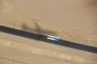 视图从窗口飞机和影子从飞机移动路沙漠空中视图公共汽车旅行沿着高速公路沙漠空中视图路沙漠高速公路穿越通过桑迪土地视图从窗口飞机和影子从飞机移动路沙漠