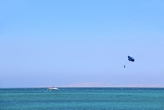 男人。喜欢帆伞运动在红色的海热带度假胜地埃及人休息埃及度假胜地旅行概念飞行降落伞后面船夏天假期男人。喜欢帆伞运动在红色的海热带度假胜地埃及