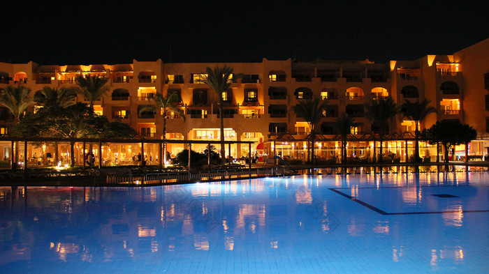 游泳池与蓝色的水和晚上酒店假期人放松晚上附近池灯晚上酒店是反映了池水晚上明亮的灯度假胜地酒店游泳池与蓝色的水和晚上酒店假期