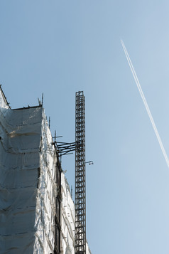 塔块建设电梯索具和飞机航迹云的对蓝色的天空