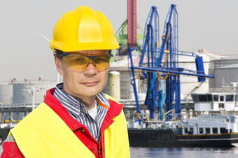 肖像自信码头工人工头前面石化港与气体安装众多起重机而且运费船
