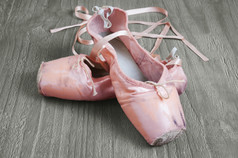 老使用粉红色的芭蕾舞鞋子木背景
