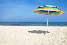 色彩斑斓的海滩伞的桑迪海滩夏天一天蓝色的天空而且海的背景