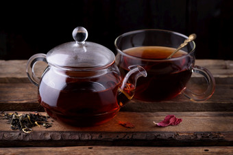 玻璃<strong>茶壶</strong>和杯与茶木背景黑暗仍然生活