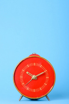 复古的老红色的时钟蓝色的背景与复制空间