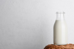 瓶牛奶柳条篮子与白色背景复制空间