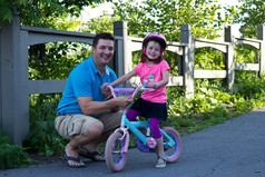 父亲而且女儿分享快乐时刻而学习骑自行车
