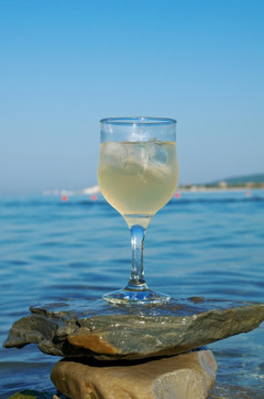 玻璃白色酒的coaston的岩石洗的波的海