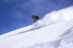 滑雪板搭便车者的山与蓝色的天空的背景