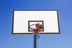 篮球球打击的篮子的蓝色的天空背景